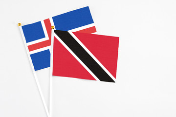 Trinidad And Tobago and Iceland stick flags on white background. High quality fabric, miniature national flag. Peaceful global concept.White floor for copy space.