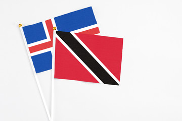 Fototapeta premium Trinidad And Tobago and Iceland stick flags on white background. High quality fabric, miniature national flag. Peaceful global concept.White floor for copy space.