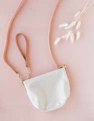 Modern shiny leather purse on pink background