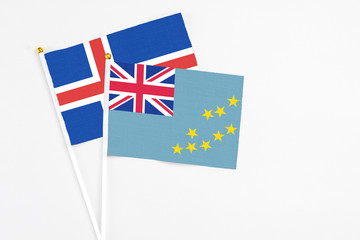 Fototapeta premium Tuvalu and Iceland stick flags on white background. High quality fabric, miniature national flag. Peaceful global concept.White floor for copy space.