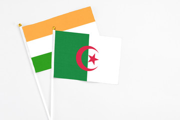 Algeria and India stick flags on white background. High quality fabric, miniature national flag....