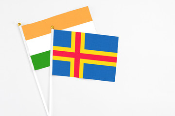 Aland Islands and India stick flags on white background. High quality fabric, miniature national flag. Peaceful global concept.White floor for copy space.