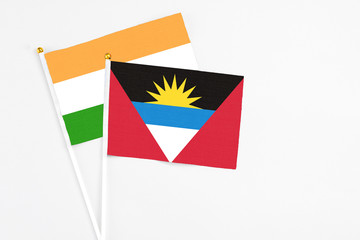 Antigua and Barbuda and India stick flags on white background. High quality fabric, miniature national flag. Peaceful global concept.White floor for copy space.