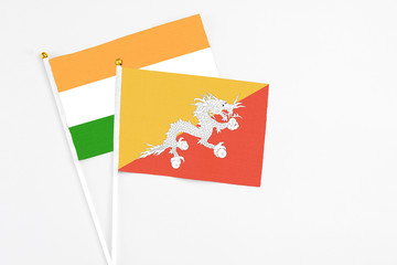 Bhutan and India stick flags on white background. High quality fabric, miniature national flag. Peaceful global concept.White floor for copy space.