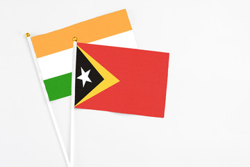 East Timor and India stick flags on white background. High quality fabric, miniature national flag. Peaceful global concept.White floor for copy space.