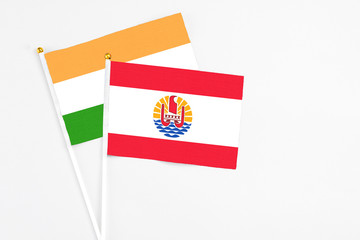 French Polynesia and India stick flags on white background. High quality fabric, miniature national flag. Peaceful global concept.White floor for copy space.