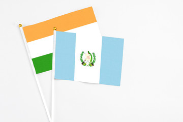 Guatemala and India stick flags on white background. High quality fabric, miniature national flag. Peaceful global concept.White floor for copy space.