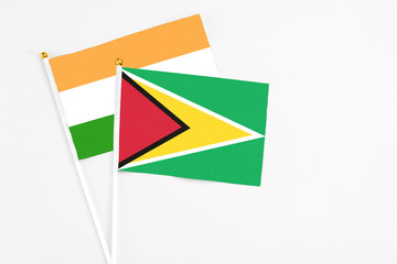 Guyana and India stick flags on white background. High quality fabric, miniature national flag. Peaceful global concept.White floor for copy space.