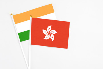 Hong Kong and India stick flags on white background. High quality fabric, miniature national flag. Peaceful global concept.White floor for copy space.