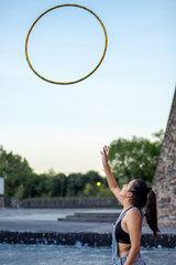 Young Woman performs hula hoop in the park
