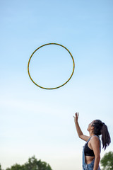 Young Woman performs hula hoop in the park