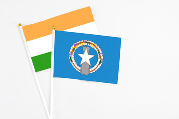 Northern Mariana Islands and India stick flags on white background. High quality fabric, miniature national flag. Peaceful global concept.White floor for copy space.