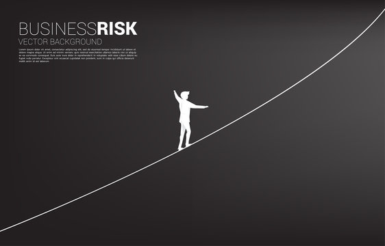 Silhouette of businessman walking on rope walk way.Concept for business risk and career path
