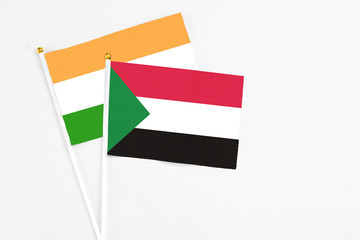 Sudan and India stick flags on white background. High quality fabric, miniature national flag. Peaceful global concept.White floor for copy space.