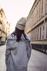 An Unrecognizable Woman walking along  an empty street 
