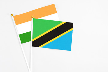 Tanzania and India stick flags on white background. High quality fabric, miniature national flag. Peaceful global concept.White floor for copy space.
