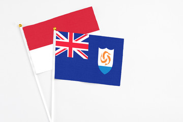 Fototapeta premium Anguilla and Indonesia stick flags on white background. High quality fabric, miniature national flag. Peaceful global concept.White floor for copy space.