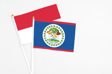 Belize and Indonesia stick flags on white background. High quality fabric, miniature national flag. Peaceful global concept.White floor for copy space.