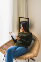 Portrait beautiful young asian women reading book and sitting on sofa chair