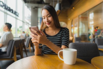 Portrait beautiful young asian women in coffee shop cafe and restaurant with mobile phone