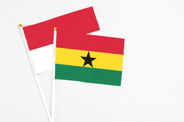 Ghana and Indonesia stick flags on white background. High quality fabric, miniature national flag. Peaceful global concept.White floor for copy space.