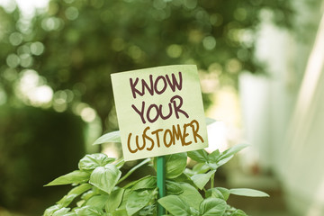 Handwriting text writing Know Your Customer. Conceptual photo Marketing creating a poll improve product or brand Plain empty paper attached to a stick and placed in the green leafy plants