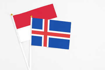 Iceland and Indonesia stick flags on white background. High quality fabric, miniature national flag. Peaceful global concept.White floor for copy space.