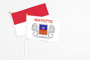 Mayotte and Indonesia stick flags on white background. High quality fabric, miniature national flag. Peaceful global concept.White floor for copy space.