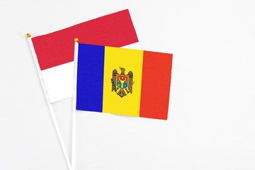 Moldova and Indonesia stick flags on white background. High quality fabric, miniature national flag. Peaceful global concept.White floor for copy space.
