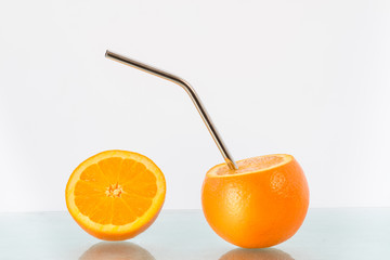 Naklejka na ściany i meble Concept image for no unnecessary packaging and environmental consciousness showing fresh oranges and a reusable stainless steel drinking straw. 