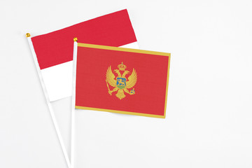 Montenegro and Indonesia stick flags on white background. High quality fabric, miniature national flag. Peaceful global concept.White floor for copy space.