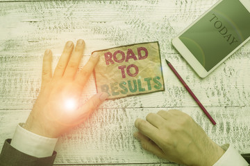Obraz premium Text sign showing Road To Results. Business photo text Business direction Path Result Achievements Goals Progress Hand hold note paper near writing equipment and modern smartphone device