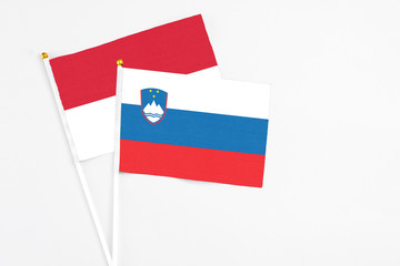 Slovenia and Indonesia stick flags on white background. High quality fabric, miniature national flag. Peaceful global concept.White floor for copy space.