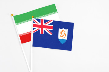 Fototapeta premium Anguilla and Iran stick flags on white background. High quality fabric, miniature national flag. Peaceful global concept.White floor for copy space.