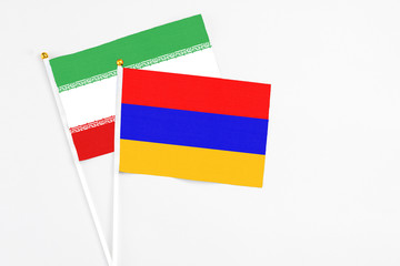 Armenia and Iran stick flags on white background. High quality fabric, miniature national flag. Peaceful global concept.White floor for copy space.