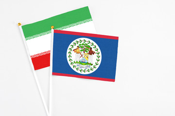Belize and Iran stick flags on white background. High quality fabric, miniature national flag. Peaceful global concept.White floor for copy space.