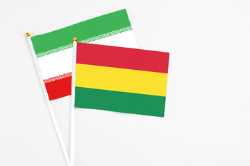 Bolivia and Iran stick flags on white background. High quality fabric, miniature national flag. Peaceful global concept.White floor for copy space.