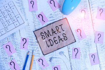 Conceptual hand writing showing Smart Ideas. Concept meaning A thought or collection of thoughts that generate in the mind Writing tools and scribbled paper on top of the wooden table