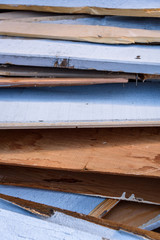 Closeup of old weathered and painted wood siding inside a construction dumpster