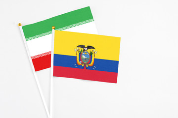 Ecuador and Iran stick flags on white background. High quality fabric, miniature national flag. Peaceful global concept.White floor for copy space.