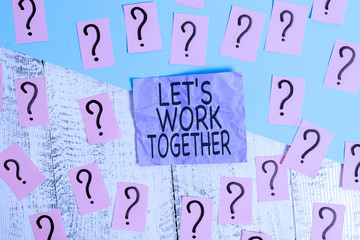 Text sign showing Let S Work Together. Business photo showcasing Unite and Join Forces to Achieve a Common Goal Scribbled and crumbling papers with thick cardboard above wooden table