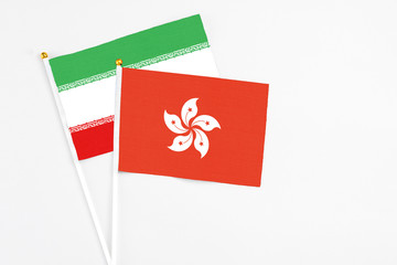 Hong Kong and Iran stick flags on white background. High quality fabric, miniature national flag. Peaceful global concept.White floor for copy space.