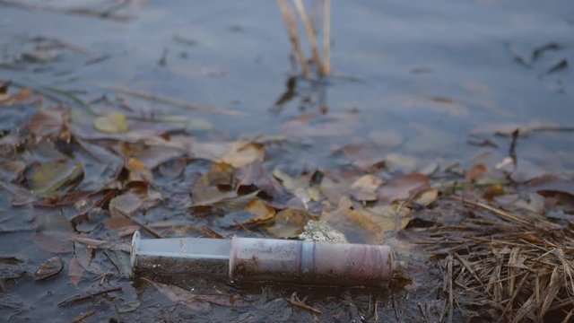 Environmental pollution by medical waste. Syringe after drug injection
