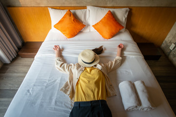 Funny shot of woman sleeping on bed, raised her hands with comfortable cushion bed. Conceptual of...