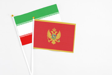 Montenegro and Iran stick flags on white background. High quality fabric, miniature national flag. Peaceful global concept.White floor for copy space.