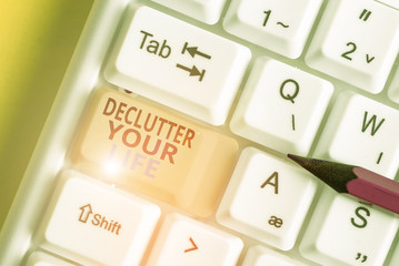 Text sign showing Declutter Your Life. Business photo text To eliminate extraneous things or information in life White pc keyboard with empty note paper above white background key copy space
