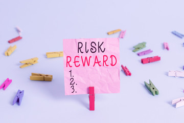 Handwriting text Risk Reward. Conceptual photo assess the profit potential of a trade relative to its loss Colored clothespin rectangle square shaped paper light blue background