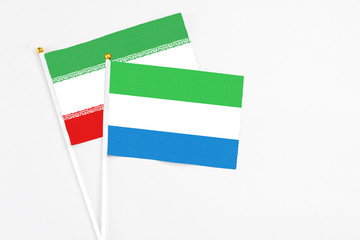 Sierra Leone and Iran stick flags on white background. High quality fabric, miniature national flag. Peaceful global concept.White floor for copy space.