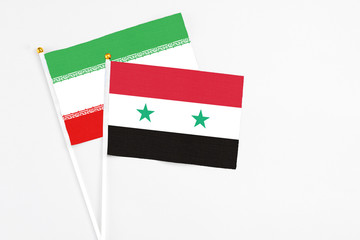 Syria and Iran stick flags on white background. High quality fabric, miniature national flag. Peaceful global concept.White floor for copy space.