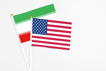 United States and Iran stick flags on white background. High quality fabric, miniature national flag. Peaceful global concept.White floor for copy space.